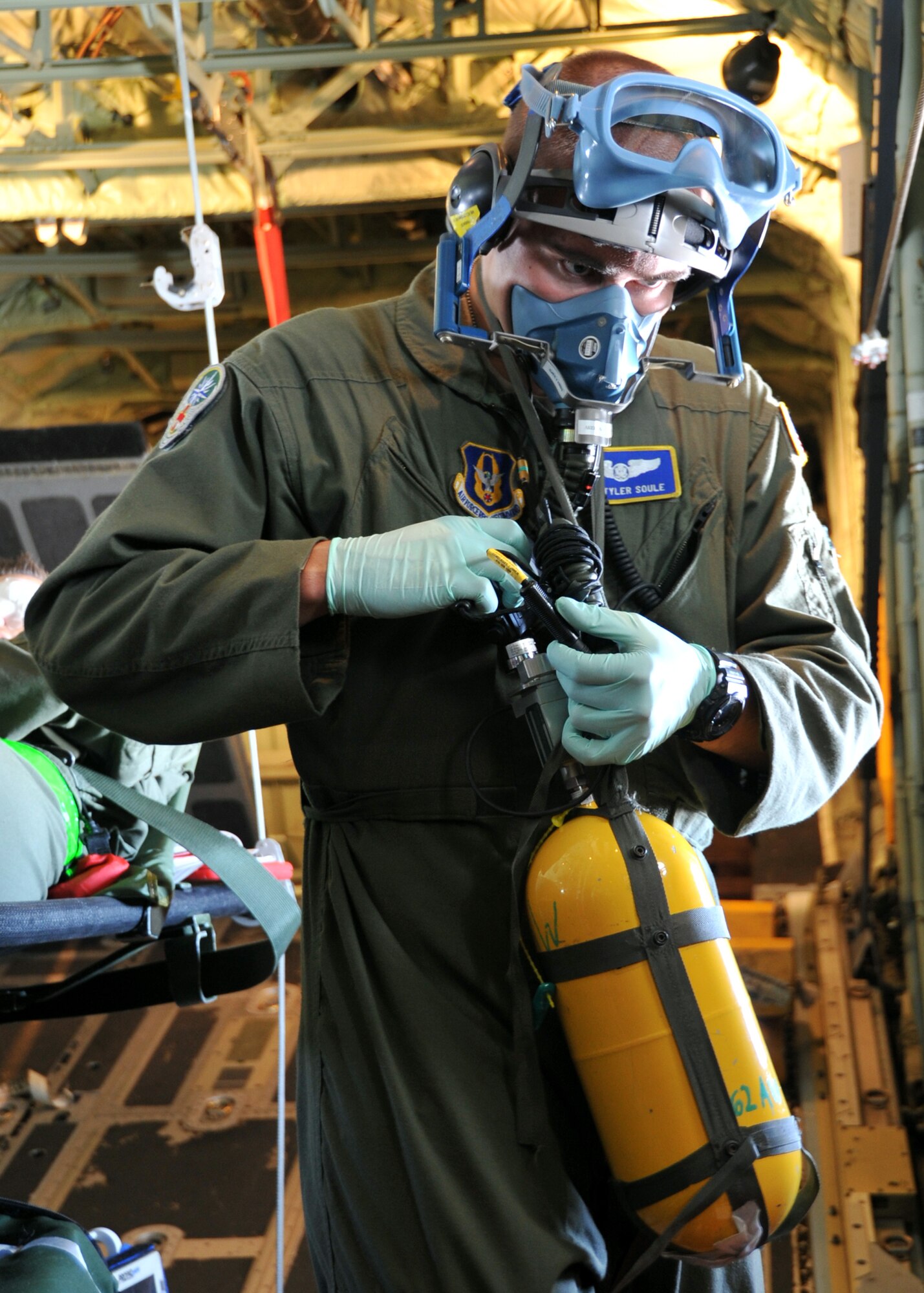 Senior Airman Tyler Soule, 446th Aeromedical Evacuation Squadron medical technician, puts on his oxygen mask during a simulated emergency June 13, 2014, at McChord Field, Wash. The 446th AES teamed up with the 53rd Weather Reconnaissance Squadron's Hurricane Hunters for inflight medical training June 13-15, 2014. (U.S. Air Force photo/Maj. Marnee A.C. Losurdo)