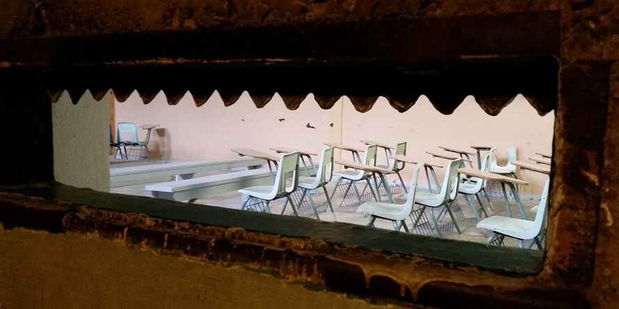 Guards could monitor inmates from concrete tunnels ringing common areas. This gun port looks into the chapel in the administrative building of the old Montana state prison. More secure than catwalks, the tunnels could not be breached during a riot. (U.S. Air Force photo / John Turner)