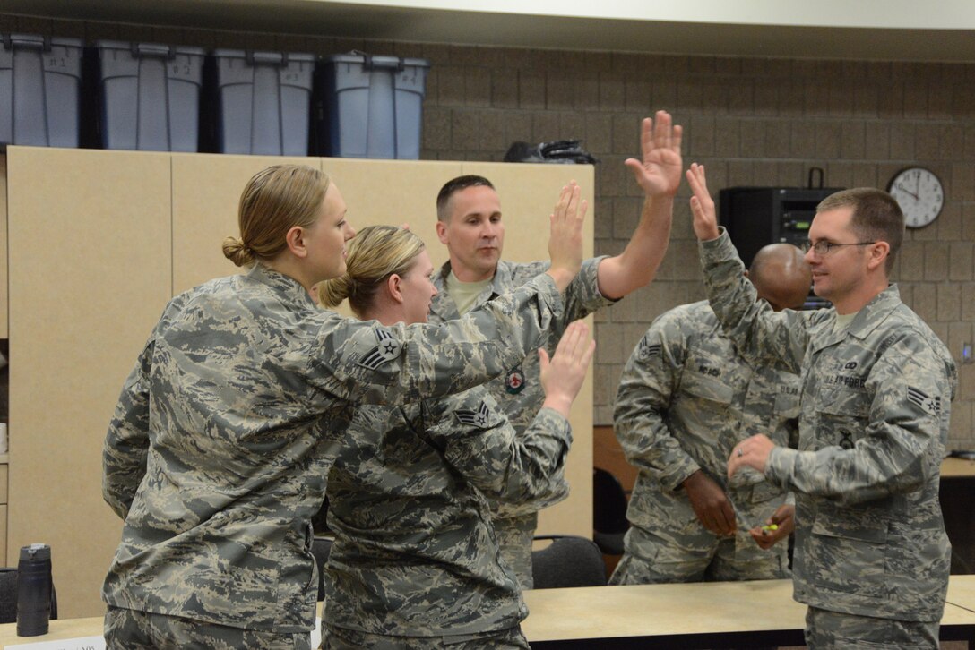 Airman Leadership School (ALS) students from the North Dakota Air National Guard’s 119th Wing give each other a high-five upon completion of a knowledge based contest during a class at the Guard’s Air Base, Fargo, N.D., June 12, 2014. The five-week ALS course is among the first in the country being offered by active duty instructors at an Air National Guard base. Instructors traveling to students’ location are a cost effective way of conducting training. (U.S. Air National Guard photo by SMSgt. David H. Lipp/Released)