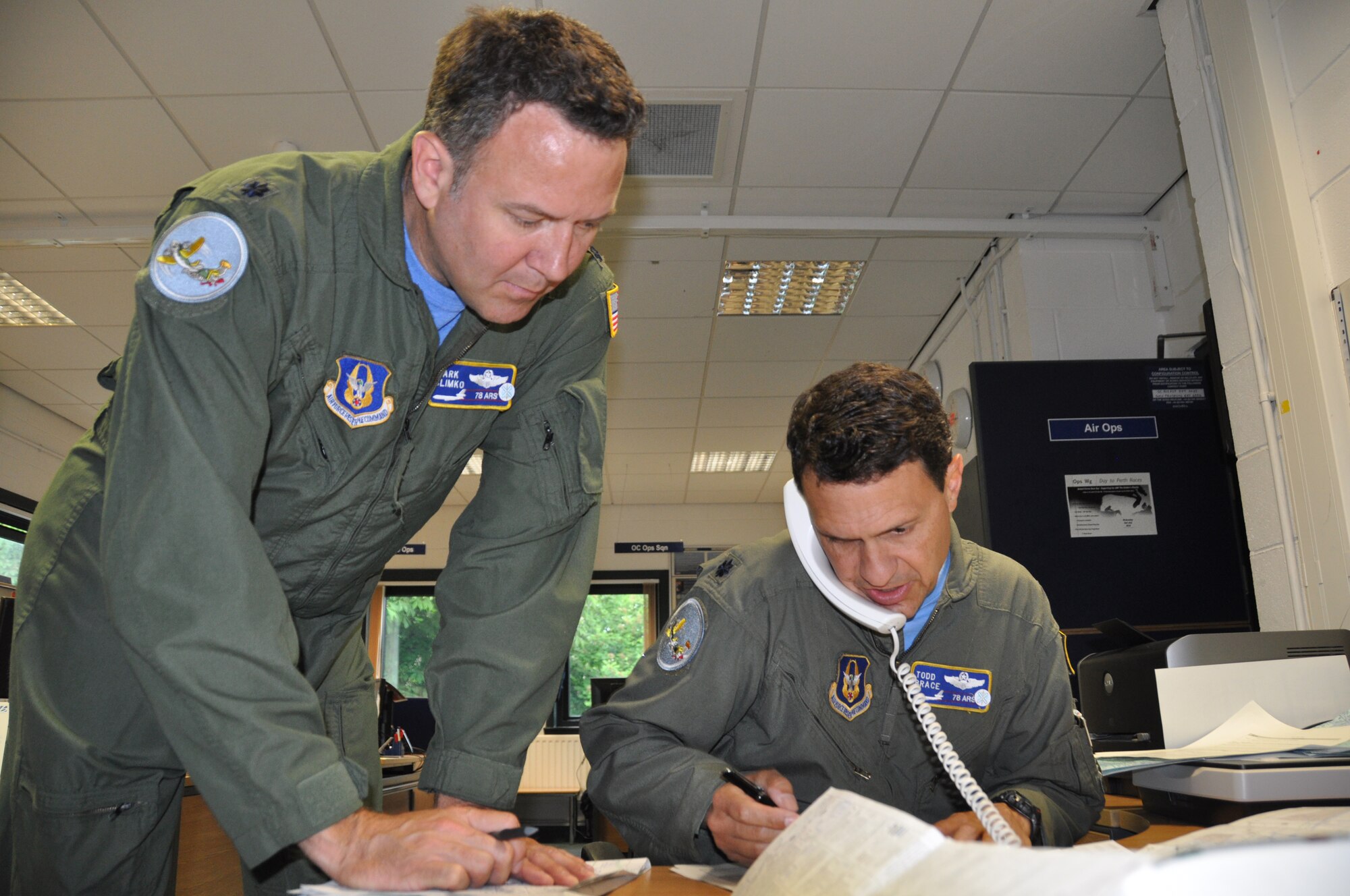Reserve KC-10 Extender instructor pilots, Lt. Cols. Mark Slimko and Todd Brace, left to right; finalize flight plans with mission planners at Royal Air Force Leuchars, United Kingdom, June 6, prior to takeoff on a refueling training mission. The tanker crew, stationed at Joint Base McGuire-Dix-Lakehurst, N.J., refueled seven Eurofighter Typhoon jets, flown by RAF pilots with the 6 Squadron from RAF Leuchars, over European skies on the 70th Anniversary of D-Day. (U.S. Air Force photo/Master Sgt. Donna T. Jeffries)