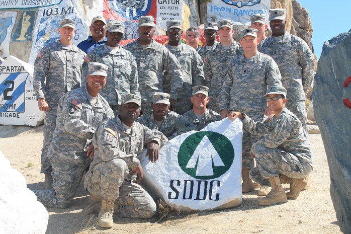 Members of the 841st Transportation Battalion Deployment and Distribution Support Team, stand behind the SDDC rock that will establish the “Transporters” as one of the pillars supporting the commands at Fort Irwin, Calif. (U.S. Army photo/ Cpl. Denis Ortizrosa)
