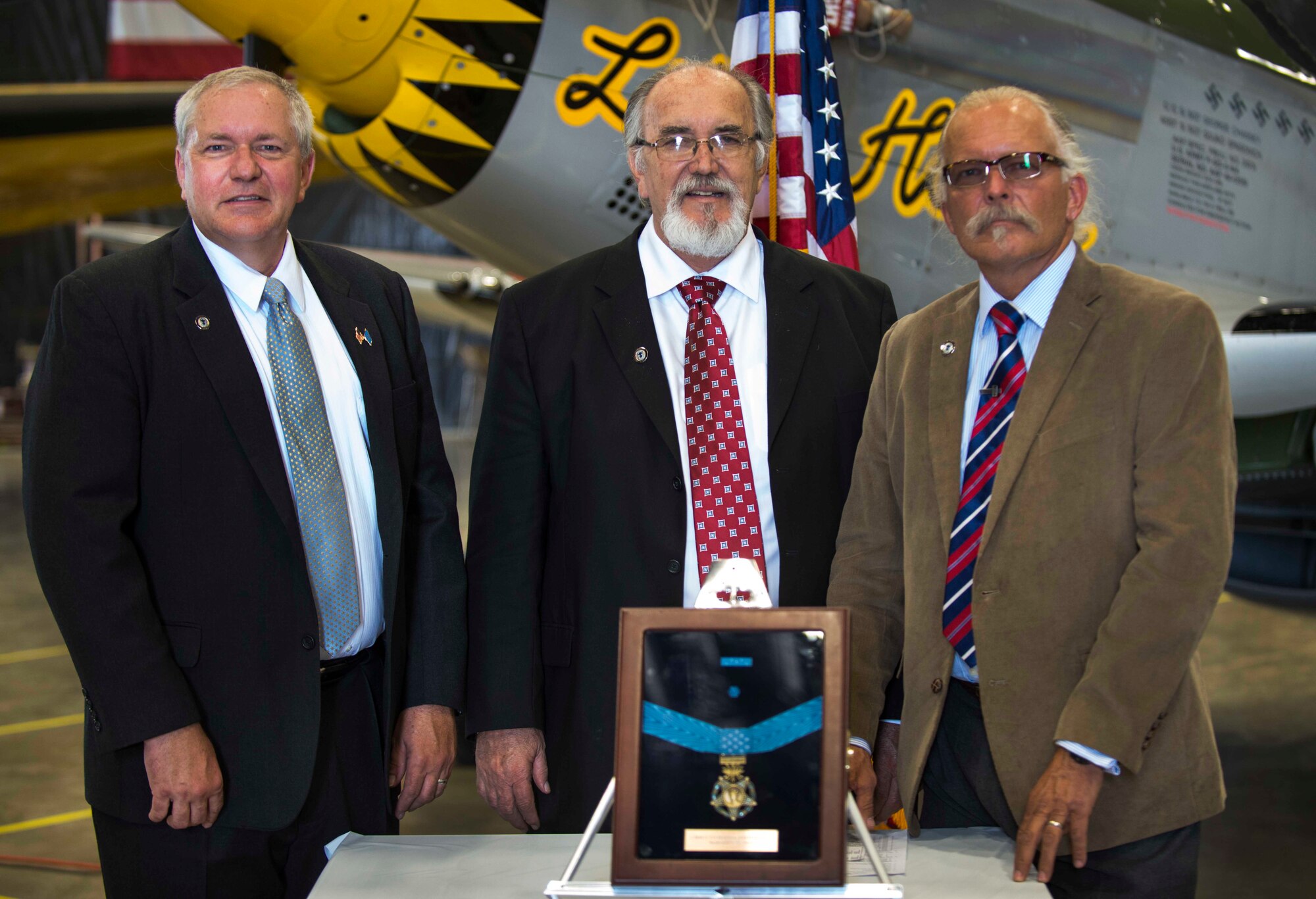 Brothers Cory Etchberger, Steve Wilson, and Rich Etchberger, stand behind their father’s Medal of Honor at the Minot Air Museum in Minot, N.D., June 5, 2014. Their father, Chief Master Sgt. Richard L. Etchberger was killed in action in Laos in 1968, and received the award posthumously in 2010. (U.S. Air Force photo/Airman 1st Class Lauren Pitts) 