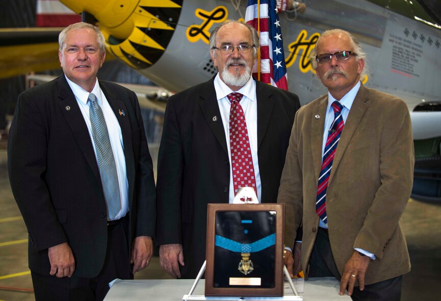 Brothers Cory Etchberger, Steve Wilson, and Rich Etchberger, stand behind their father’s Medal of Honor at the Minot Air Museum in Minot, N.D., June 5, 2014. Their father, Chief Master Sgt. Richard L. Etchberger was killed in action in Laos in 1968, and received the award posthumously in 2010. (U.S. Air Force photo/Airman 1st Class Lauren Pitts) 
