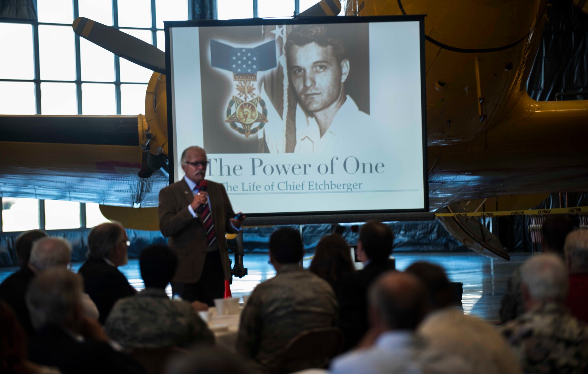 Rich Etchberger, son of Medal of Honor recipient Chief Master Sgt. Richard L. Etchberger, speaks to members of Team Minot during the Military Affairs Committee lunch about his father at the Minot Air Museum in Minot, N.D., June 5, 2014. Chief Etchberger gave his life in the Vietnam War during a mission to Laos, and became the first chief master sergeant ever to receive the award. (U.S. Air Force photo/Airman 1st Class Lauren Pitts) 
