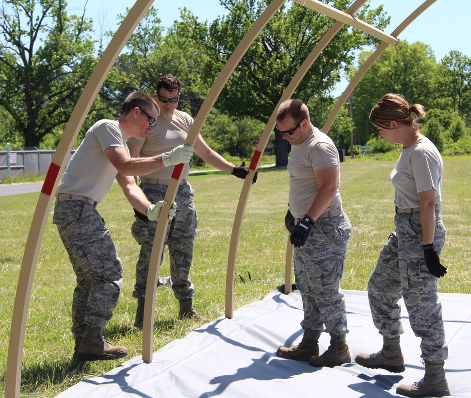 From left, Maj. Chad Timberlake, Master Sgt. Riley Krug, Staff Sgt. Brenton Darnell and Staff Sgt. Kristi Dimarco, members of the 932nd Airlift Wing Medical Group, secure metal beams to floor of an Alaskan tent.  Member of the 932nd AW Medical Group worked for several hours to get the tent up and ready to go in preparation for a training exercise this month. (U.S. Air Force Photo/Staff. Sgt. Meiko Schill)