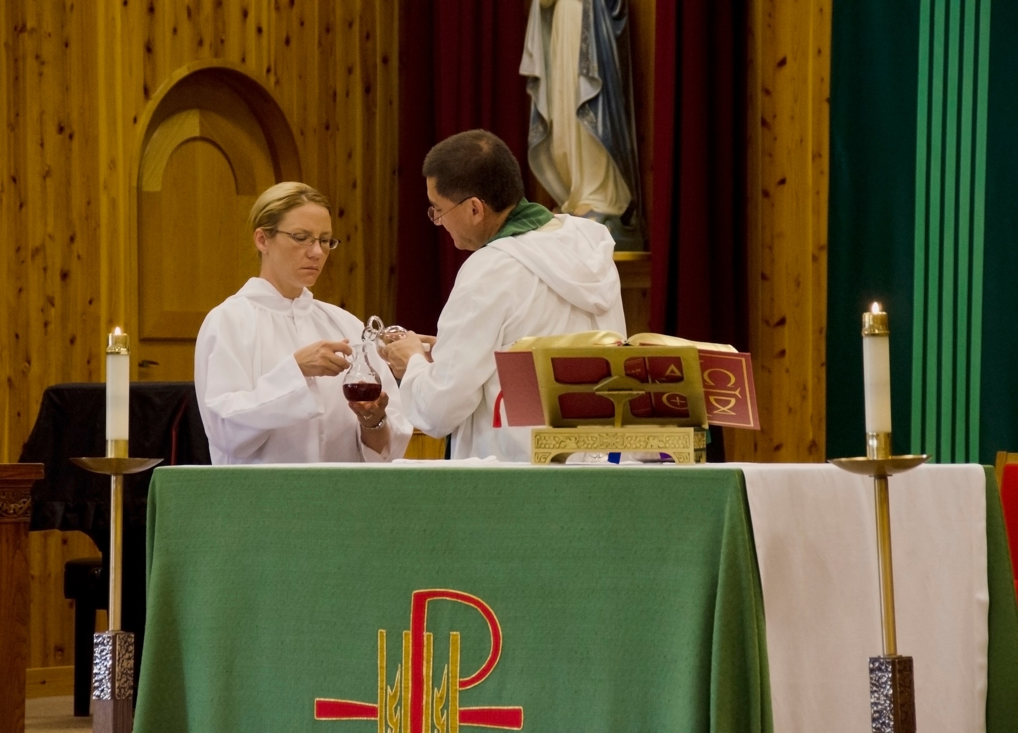 Capt. Carlos Bohorquez, a chaplain, and Master Sgt. Melissa Macke, a chaplains assistant, both with the 126th Air Refueling Wing, conduct mass at the chapel on Naval Air Facility, Atsugi, Japan, June 12, 2014. The Illinois Air National Guard chaplain's office, from Scott Air Force Base, Ill., is providing assistance to offices at NAF Atsugi while gaining training experience. (Air National Guard photo by Senior Airman Laura Muehl)