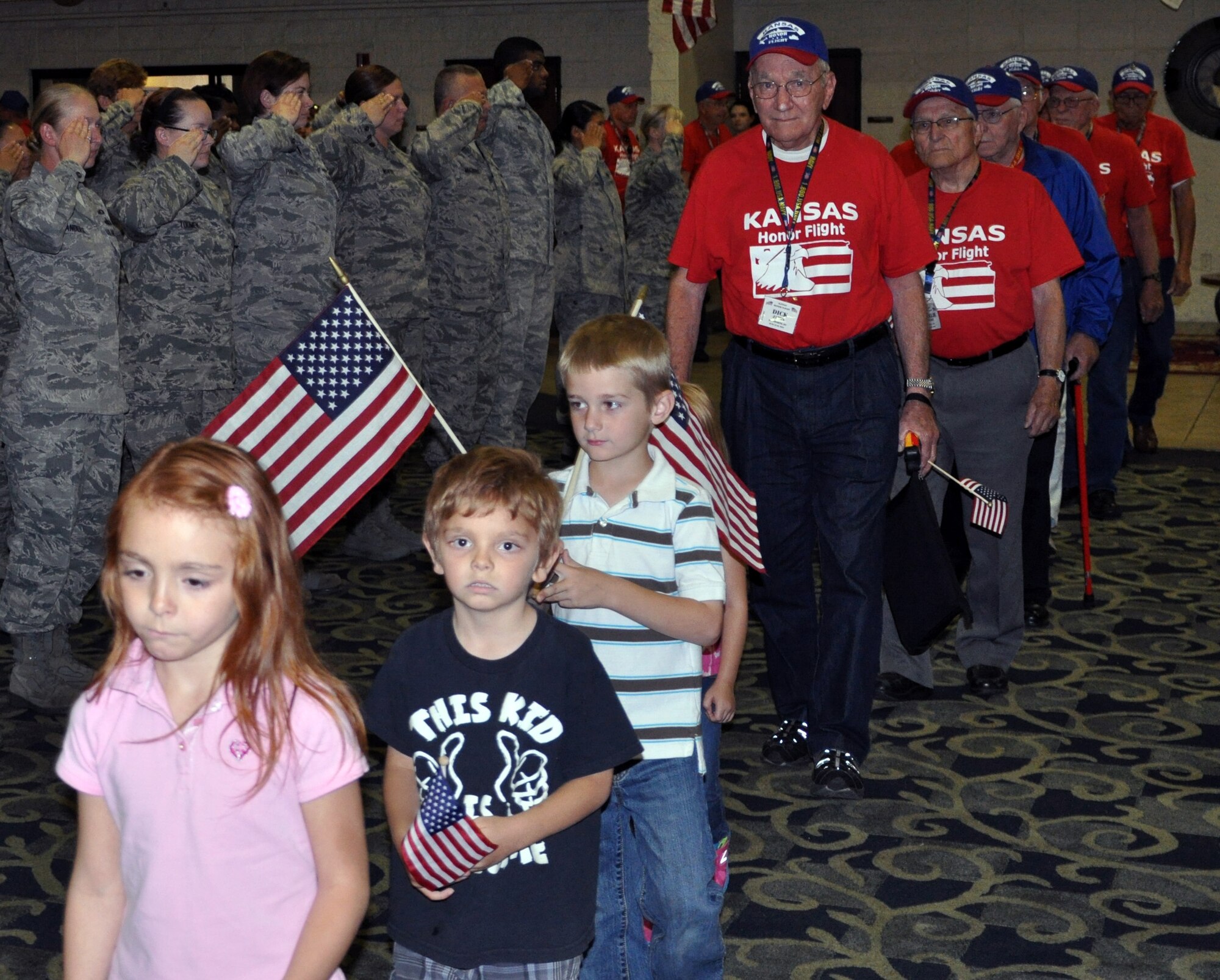 Members of the Air force Reserve 931st Air Refueling Group salute a group of World Ware II and Korean War Veterans as the Veterans return from an Honor Flight during a welcome home ceremony in Wichita, Kan., June 13, 2014. Family members, community supporters, and more than 40 members of Team McConnell were on hand at the ceremony to greet the Veterans as they returned home from their Honor Flight to Washington, D.C. Honor Flights are conducted by a non-profit organization, and take Veterans to see their war memorials and other sites in the U.S. Capitol. (U.S. Air Force photo by Capt. Zach Anderson)