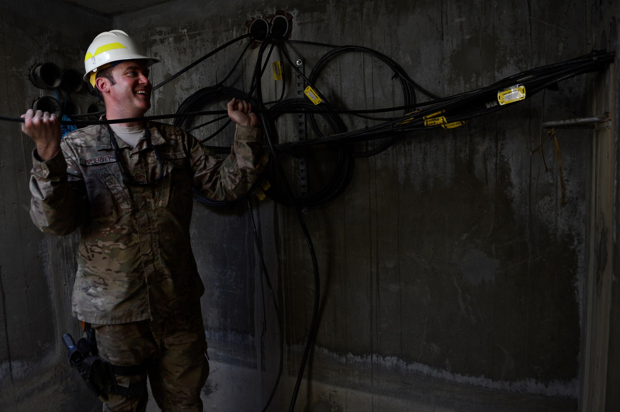 Tech. Sgt. Christopher Meservey, Combined Air and Space Operations Center Engineering and Installations cable and antenna team chief, pushes a cable to Senior Airman Ariel Roldan, Combined Air and Space Operations Center Engineering and Installations cable and antenna technician, at Bagram Airfield, Afghanistan, May 15, 2014. The cable is being used at the Air Traffic Control Tower and Command Post to provide connections for several necessary communication supports needed throughout the base. Meservey, a Worcester, Mass. native and Roldan, a Worcester, Mass. native are deployed from the 212th Engineering and Installation Squadron, Otis Air National Guard Base, Mass. (U.S. Air Force photo by Senior Airman Sandra Welch)