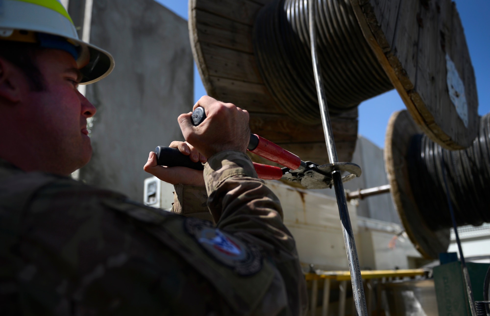 Tech. Sgt. Christopher Meservey, Combined Air and Space Operations Center Engineering and Installations cable and antenna team chief, cuts a cable after running the cable to the Air Traffic Control Tower at Bagram Airfield, Afghanistan, May 15, 2014. The cable is being used at the Air Traffic Control Tower and Command Post to provide connections for several necessary communication supports needed throughout the base. Meservey, a Worcester, Mass. native is deployed from the 212th Engineering and Installation Squadron, Otis Air National Guard Base, Mass. (U.S. Air Force photo by Senior Airman Sandra Welch)