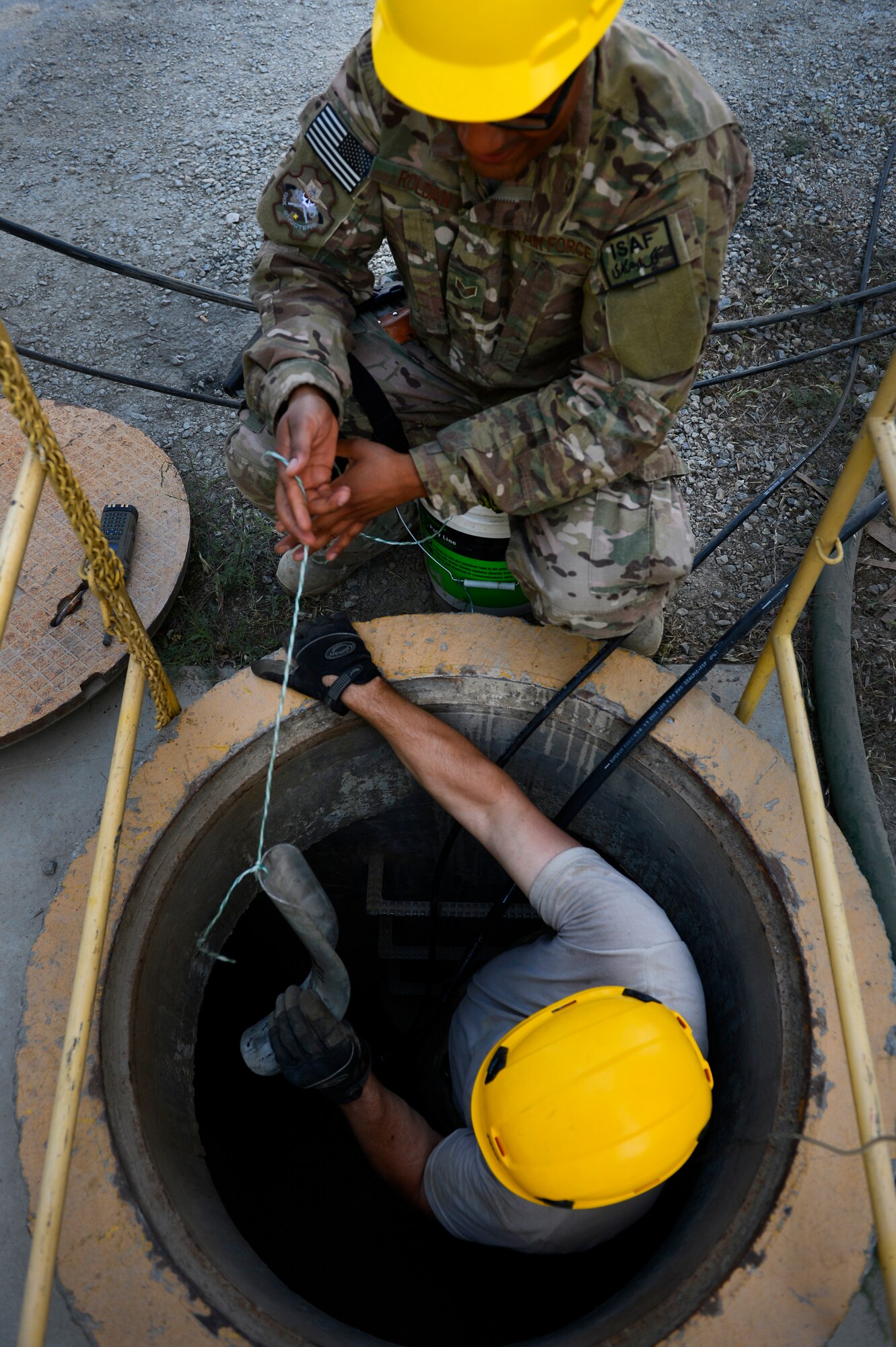 Staff Sgt. Lawence Santos, and Senior Airman Ariel Roldan, Combined Air and Space Operations Center Engineering and Installations cable and antenna technician, prepare a cable shoe before running cables at Bagram Airfield, Afghanistan, May 15, 2014. The cable shoe will help prevent damage to the cable from rough or sharp surfaces. Santos, a East Taunton, Mass. native and Roldan, a Worcester, Mass. native are deployed from the 212th Engineering and Installation Squadron, Otis Air National Guard Base, Mass. (U.S. Air Force photo by Senior Airman Sandra Welch)