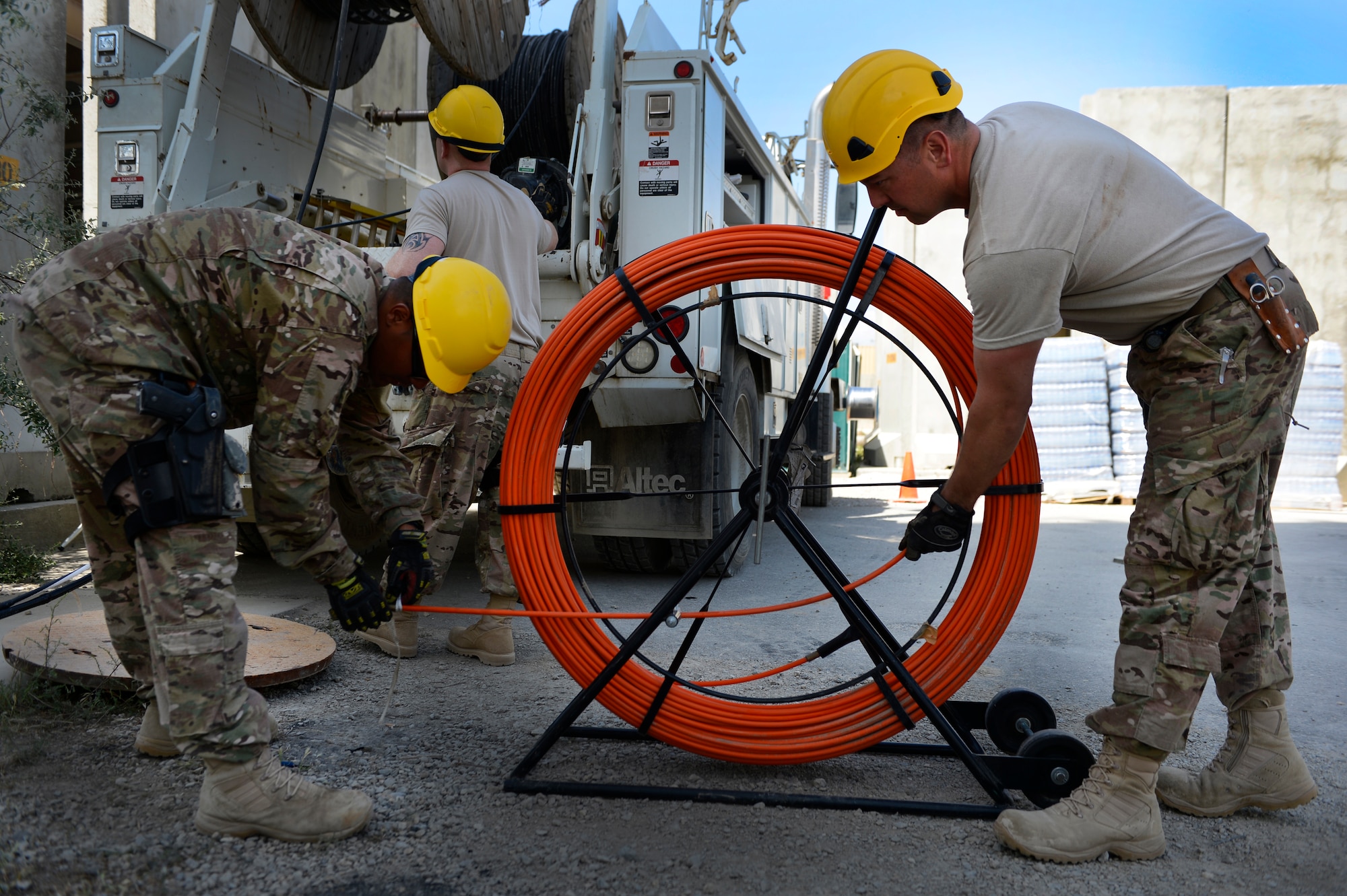 U.S. Air Force Staff Sgt. Lawence Santos, and Senior Airman Ariel Roldan, Combined Air and Space Operations Center Engineering and Installations cable and antenna technician, prepare the duct rod before running a cable at Bagram Airfield, Afghanistan, May 15, 2014. The cable is being used at the Air Traffic Control Tower and Command Post to provide connections for several necessary communication supports needed throughout the base. Santos, a East Taunton, Mass. native and Roldan, a Worcester, Mass. native are deployed from the 212th Engineering and Installation Squadron, Otis Air National Guard Base, Mass. (U.S. Air Force photo by Senior Airman Sandra Welch)