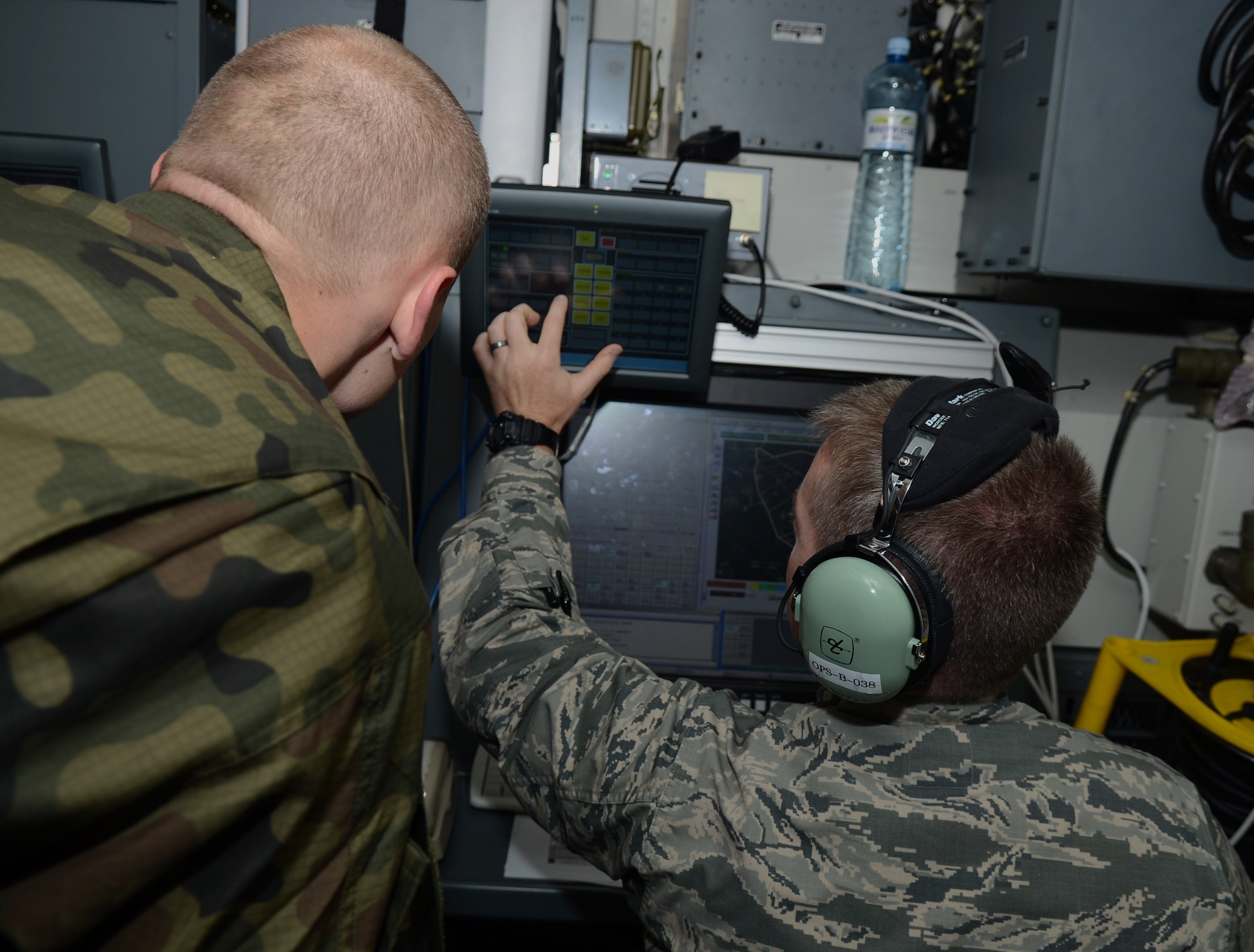 U.S. Air Force Capt. Brad Dvorak, right, 606th Expeditionary Air Control Squadron chief of weapons and tactics from Cedar Rapids, Iowa, discusses communications and control tactics with a Polish air force service member during an EAGLE TALON mission June 12, 2014, at Powidz Air Base, Poland. Exercises like EAGLE TALON enable the U.S. Air Force to promote interoperability with its European partners. (U.S. Air Force photo/Airman 1st Class Kyla Gifford/Released)