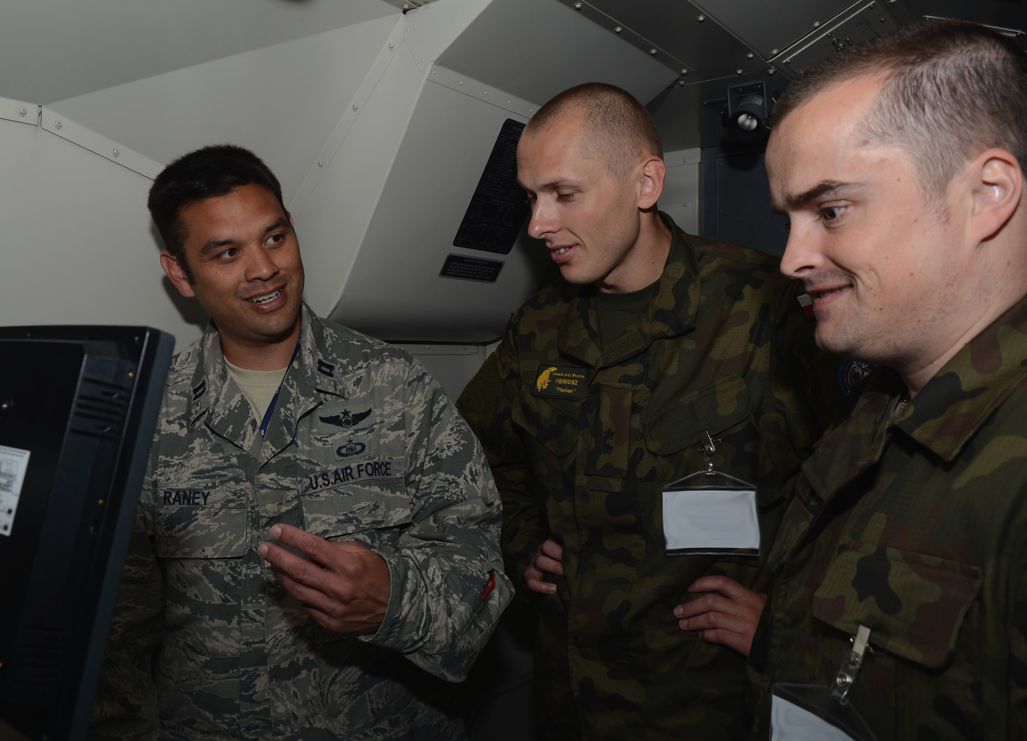 U.S. Air Force Capt. Adam Raney, left, 606th Expeditionary Air Control Squadron mission support director from Tampa, Fla., demonstrates control tactics to two Polish air force service members June 12, 2014, at Powidz Air Base, Poland. The 606th EACS is primarily supporting EAGLE TALON, a Polish-led multinational exercise, to increase interoperability with air-to-air and air-to-surface training involving Polish, U.S., French, British and NATO aircraft. (U.S. Air Force photo/Airman 1st Class Kyla Gifford/Released)