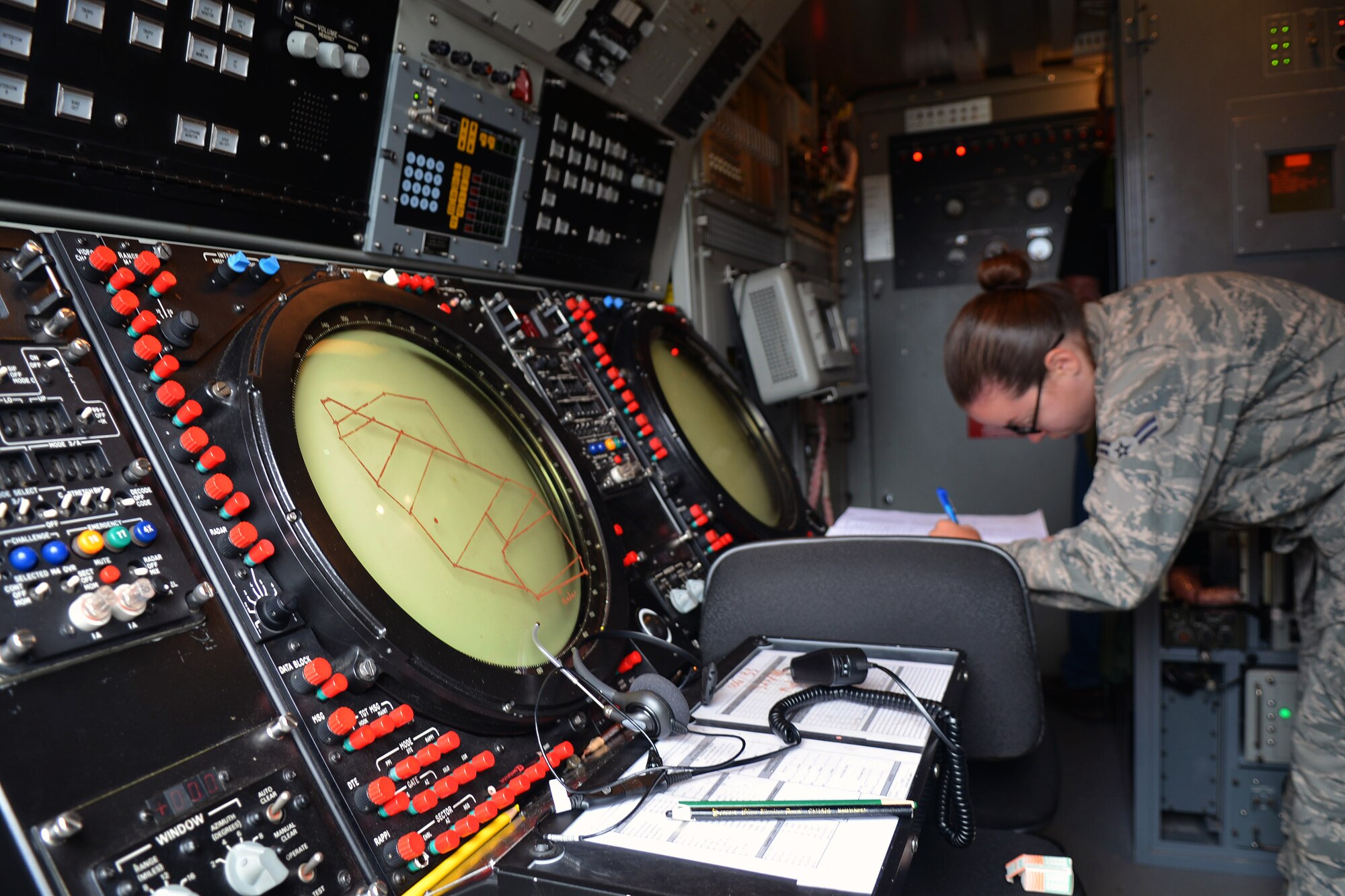 U.S. Air Force Airman 1st Class Juanita Baker, 606th Expeditionary Air Control Squadron ground radar apprentice from Damiansville, Ill., completes paperwork inside a 606th EACS radar operations trailer June 12, 2014, at Powidz Air Base, Poland. The 606th EACS serves as a Control and Reporting Center that provides tactical control to the aircraft participating in Poland's EAGLE TALON exercise and the U.S. Air Force Aviation Detachment's Rotation 14-3 training exercise. (U.S. Air Force photo/Airman 1st Class Kyla Gifford/Released)