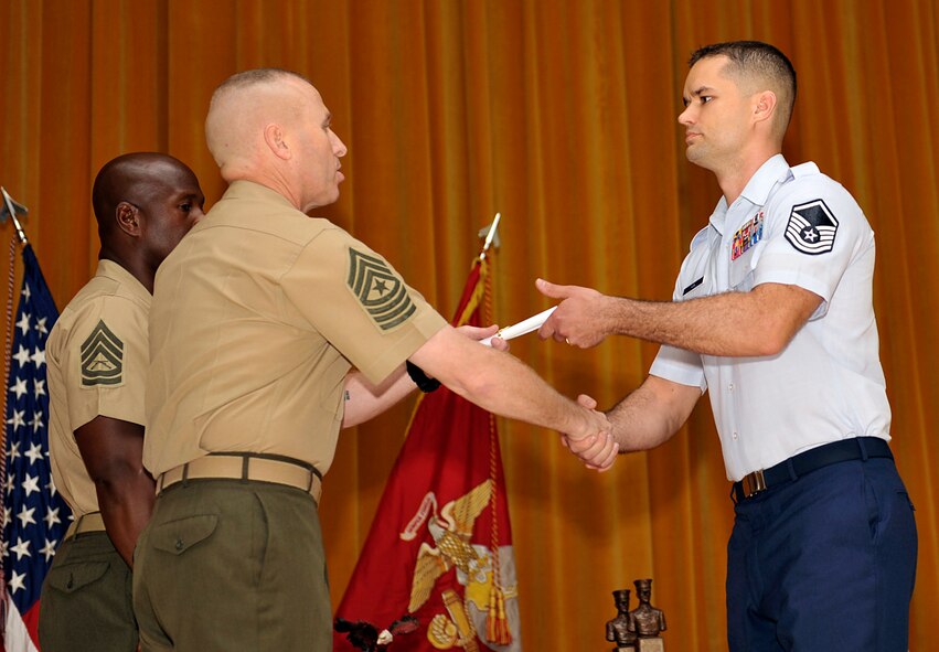 U. S. Air Force Master Sgt. CT Kirk, 718th Aircraft Maintenance Squadron production superintendent, receives a graduation certificate from U.S. Marine Corps Sgt. Maj. Jerry Bates, Headquarters and Service Battalion, Marine Corps Base, Camp Smedley D. Butler senior enlisted advisor, during the graduation ceremony of U.S. Marine Corps Staff NCO Academy Class 4-14 on Camp Hansen, Japan, June 13, 2014. Seven Airmen and Marine students attended the U.S. Marine Corps Staff NCO Academy, where they learned leadership techniques, managerial capabilities and shared their perspective of the military profession. (U.S. Air Force photo by Naoto Anazawa)