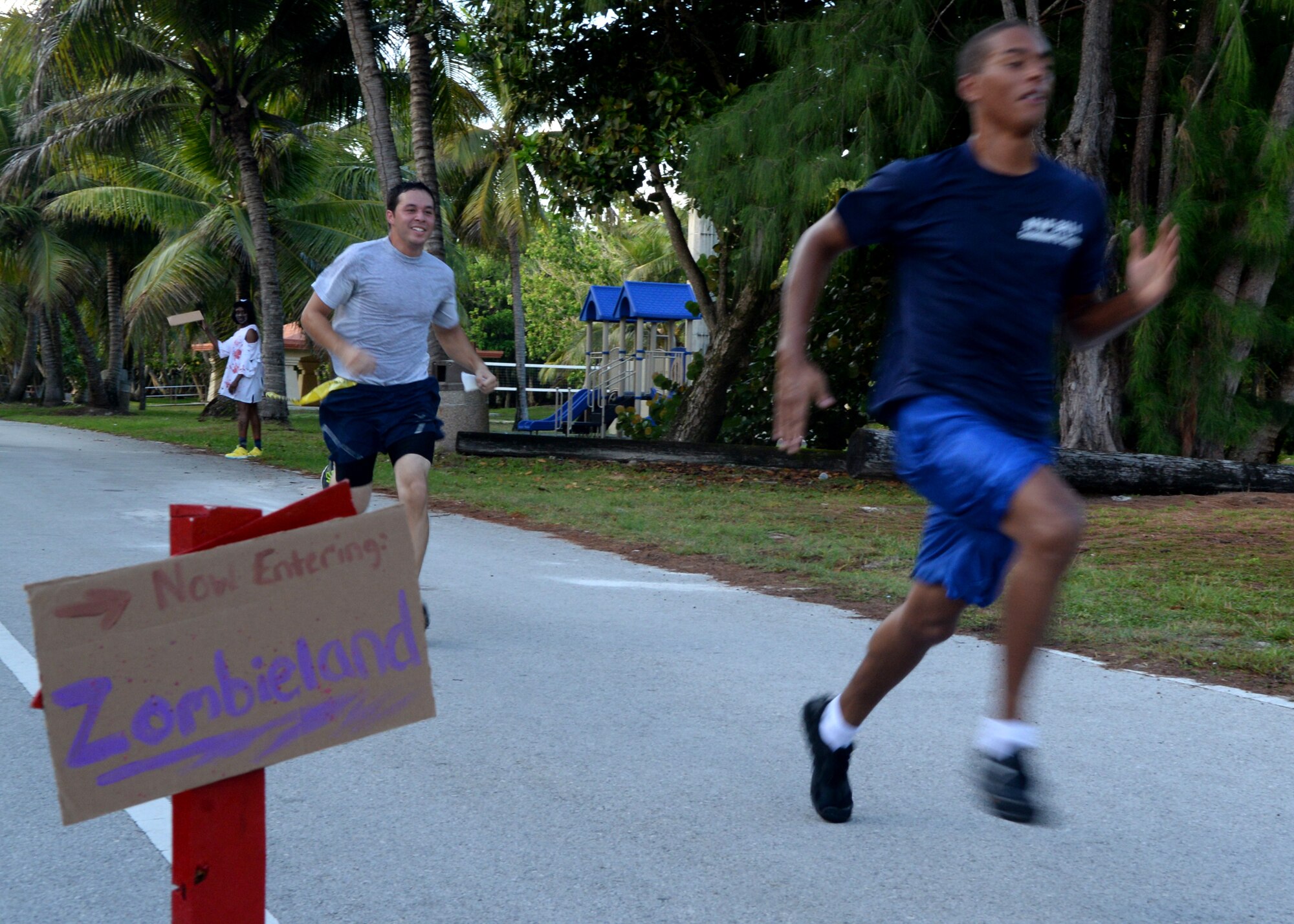 Runners sprint to the finish line during a Zombie 5K Fun Run June 11, 2014, at Tarague Beach on Andersen Air Force Base, Guam. The first male and female that finished the run without losing a “life” represented by yellow flags that hung from their belts received a trophy and the “zombie” who captured the most “lives” won a trophy. (U.S. Air Force photo by Airman 1st Class Amanda Morris/Released)