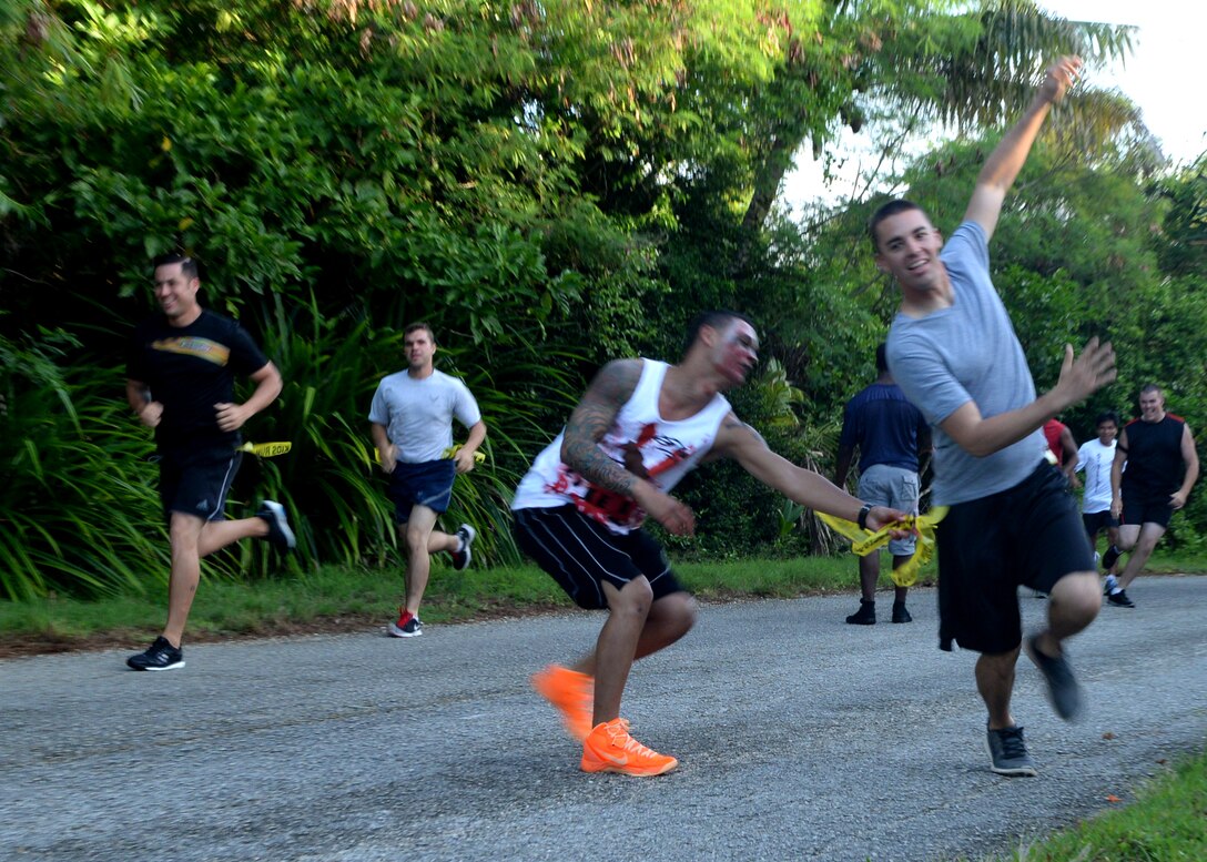A “zombie” reaches to steal a “life” from a runner during a Zombie 5K Fun Run June 11, 2014, at Tarague Beach on Andersen Air Force Base, Guam. Yellow flags that hung from belts represented “lives” that could be stolen by “zombies” that hid along the designated path. (U.S. Air Force photo by Airman 1st Class Amanda Morris/Released)