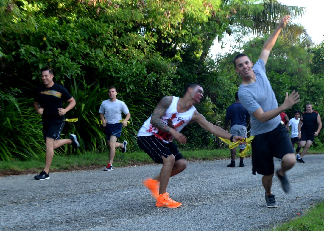 A “zombie” reaches to steal a “life” from a runner during a Zombie 5K Fun Run June 11, 2014, at Tarague Beach on Andersen Air Force Base, Guam. Yellow flags that hung from belts represented “lives” that could be stolen by “zombies” that hid along the designated path. (U.S. Air Force photo by Airman 1st Class Amanda Morris/Released)