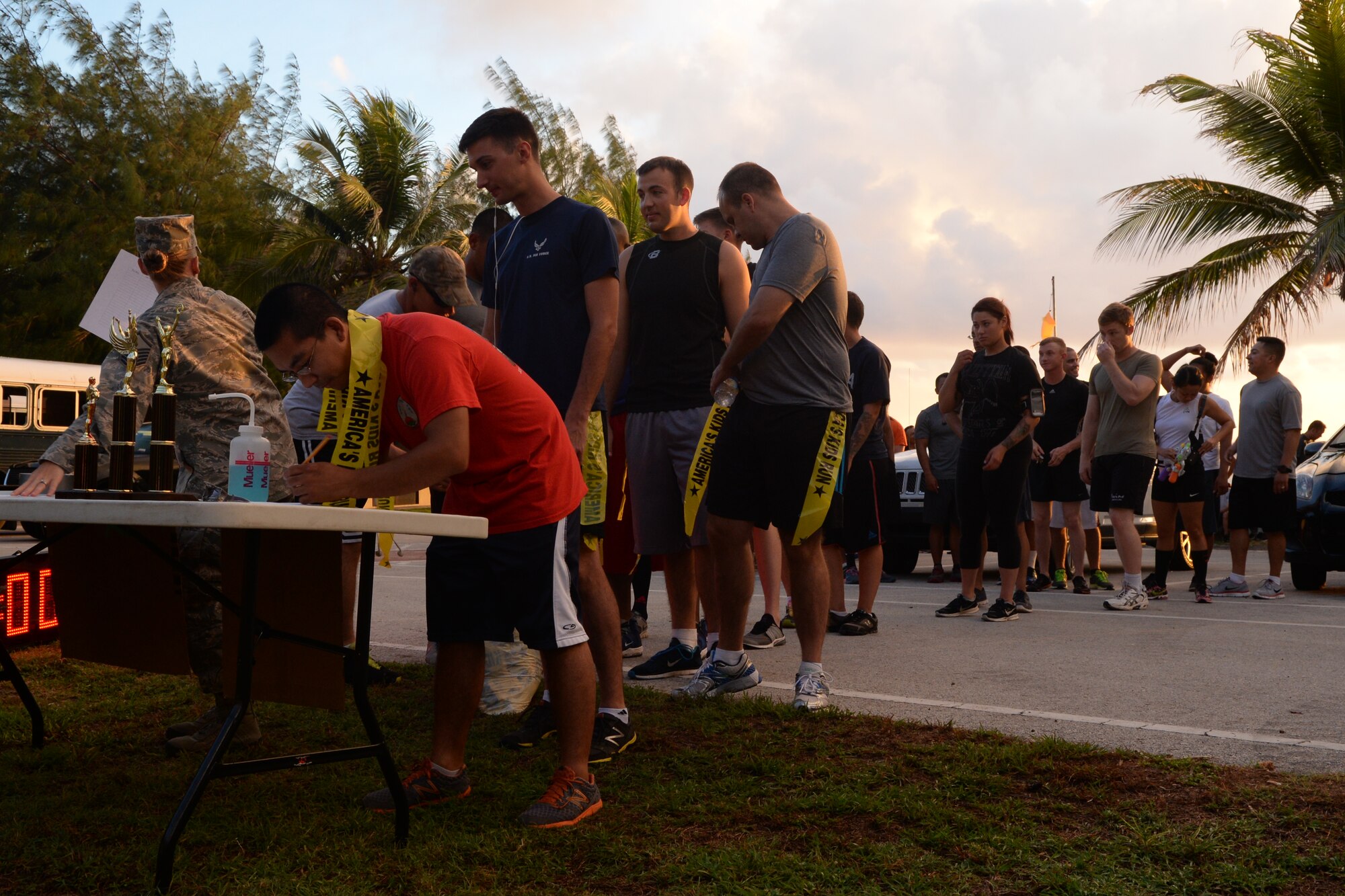 Runners sign in and receive “lives” before participating in a Zombie 5K Fun Run June 11, 2014, at Tarague Beach on Andersen Air Force Base, Guam. Yellow flags that hung from belts represented “lives” that could be stolen by “zombies” that hid along the designated path. (U.S. Air Force photo by Airman 1st Class Amanda Morris/Released)