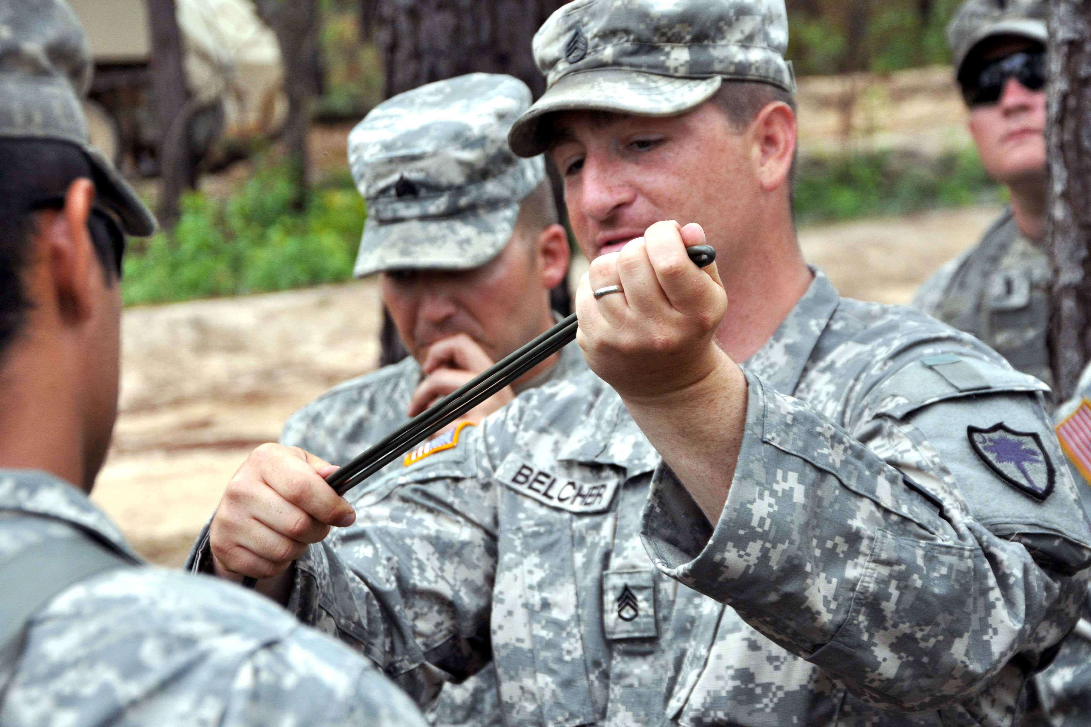 Army Staff Sgt. John Belcher, center, instructs soldiers how to prepare linear charges, water