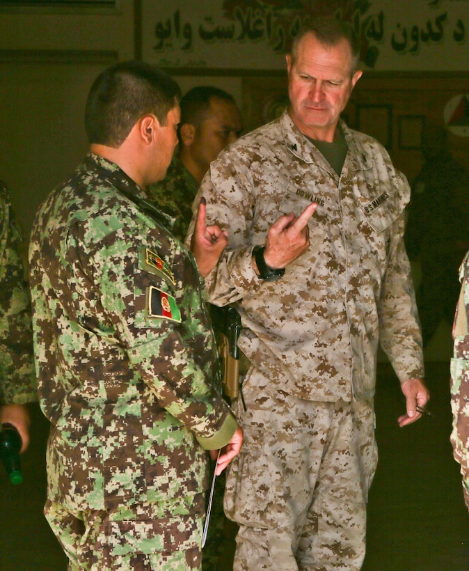 U.S. Marine Corps Col. Christopher Dowling looks at an Afghan soldier's index finger on Camp Shorabak in Afghanistan's Helmand province, June 14, 2014. The black ink on his finger indicates he voted during the presidential runoff elections. Dowling is the officer-in-charge of the Combined Corps Advisor Team.