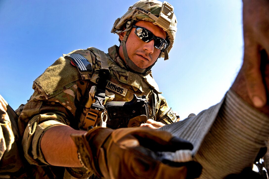 U.S. Air Force Senior Airman David Cummings wraps an elder's injured foot in Mizan, Zabul province, Afghanistan, Oct. 25, 2011. Cummings, a medic assigned to Provincial Reconstruction Team Zabul, is deployed from the 59th Medical Squadron based on Lackland Air Force Base in San Antonio, Texas.  
