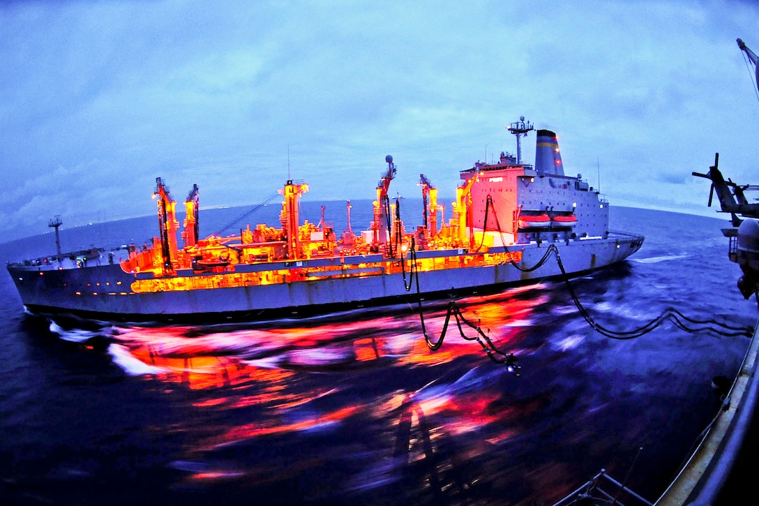 The Military Sealift Command fleet replenishment oiler USNS Rappahannock conducts a replenishment at sea with the amphibious assault ship USS Essex before sunrise in the Philippine Sea, Oct. 15, 2011. The Essex is part of the Essex Amphibious Ready Group.  
