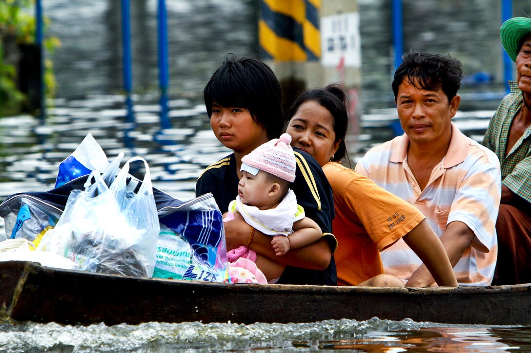 Residents navigate flood waters in Pathum Thani, Thailand, Oct. 17, 2011. A U.S. Marine Corps Humanitarian Assessment Survey Team is in the area to assess flood damage and decide if U.S. forces from the 3rd Marine Expeditionary Force could provide support to Royal Thai forces. 
