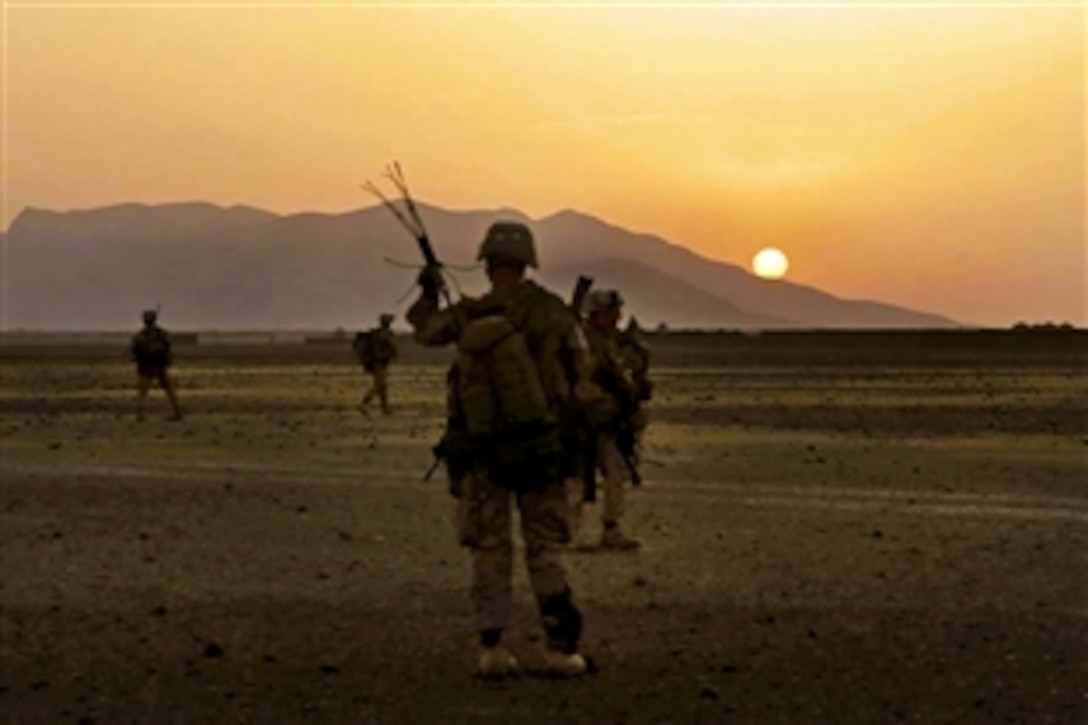 U.S. Marines maneuver into a village during a mission as the sun rises in Helmand province, Afghanistan, June 6, 2014. The Marines are assigned to assigned to Bravo Company, 1st Battalion, 7th Marine Regiment. 