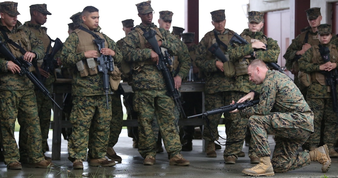 COMBINED ARMS TRAINING CENTER CAMP FUJI, SHIZUOKA, Japan – Staff Sgt. Jason G. Kelley, kneeling right, instructs Marines and sailors with Combat Logistics Regiments 35 and 37, 3rd Marine Logistics Group, on M16A4 service rifle and M4 carbine immediate and remedial action drills June 7 at Combined Arms Training Center Camp Fuji as part of Fuji Warrior. During Fuji Warrior, a biennial training exercise, Marines and sailors will execute military operations on urbanized terrain training and advanced M16 and M4 familiarization training as well as operate several crew-served weapons. Kelley is a weapons and tactics instructor with Tactical Readiness and Training, G-3, training and operations, 3rd MLG, III Marine Expeditionary Force. (U.S. Marine Corps photo by Lance Cpl. Wes J. Lucko/Released)