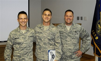 Air Force Senior Airman Zachary Phillips, center, is promoted to his present rank June 7, 2014, at a ceremony on the Portland Air National Guard Base, Ore. His brother, Air Force Senior Airman Lewis Phillips, left, and their father, Air Force Senior Master Sgt. John Phillips participated in the ceremony. 