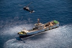 An HH-60G Pave Hawk rescue helicopter from the California Air National Guard's 129th Rescue Wing hovers over a Chinese fishing vessel, the Fu Yuan Yu #871, March 12, 2012. Guardian Angel pararescuemen from the 129th rescued two fishermen who were severely burned during an onboard diesel fire approximately 700 miles off the coast of Acapulco, Mexico.