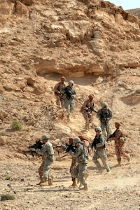 Soldiers from the Oregon National Guard's 1st Squadron, 82nd Cavalry Regiment, and Omani soldiers from the Royal Army of Oman's 11th Brigade, Western Frontier Regiment, move toward their objective during a squad assault training exercise at the Rubkut Training Range in Oman, Jan. 24, 2012. The two-week exercise, sponsored by U.S. Army Central, was meant to share knowledge and build diplomatic relations between the U.S. military and Oman.