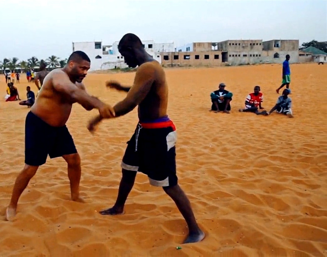 Kelly Grissom, a Brazilian Jujitsu instructor, demonstrates a technique on a Senegalese man in Senegal, Nov. 2013. Kelly Grissom co-founded the Lion Heart Initiative, a plan to teach mixed martial arts to young urban youth of Senegal, West Africa, and create better opportunities for them. 