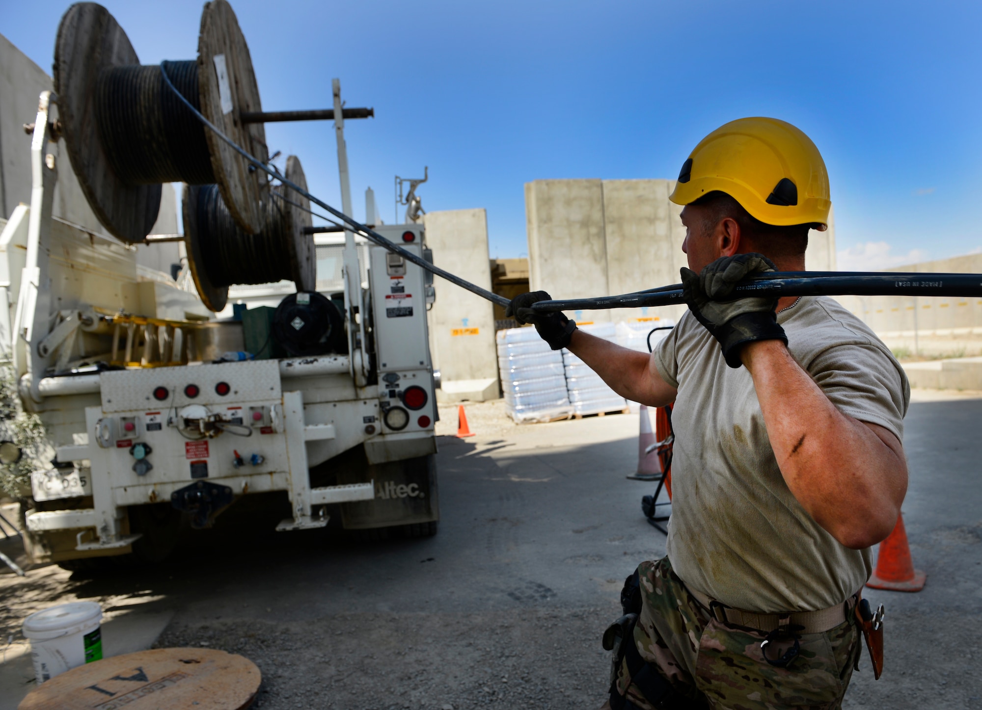 Staff Sgt. Lawence Santos pulls cables May 15, 2014, at Bagram Airfield, Afghanistan. The cable is being used at the air traffic control tower and command post to provide connections for several necessary communication supports needed throughout the base. Santos is a Combined Air and Space Operations Center Engineering and Installations cable and antenna technician. (U.S. Air Force photo/Senior Airman Sandra Welch)
