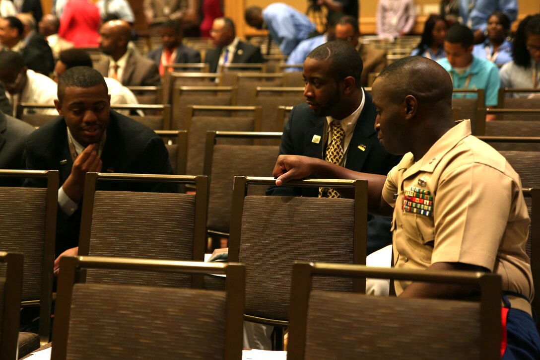 HOLLYWOOD, Fla. - Capt. Travis Perkins, enages with members of the 100 Black Men of America during the opening ceremony for the 100 Black Men of America’s national symposium at the Westin Diplomat Resort here, June 12, 2014. The Marines have partnered with 100 Black Men of America recognizing them as an institution committed to excellence in leadership that embodies the Marine Corps’ core values of honor, courage and commitment.  The Corps hopes to inform many of the organization’s more than 125,000 African American members about opportunities in the Marine Corps and to present the Marines as a viable career option. The partnership is part of the Marine Corps’ continued efforts to attract and retain diversity within its officer ranks. (Official Marine Corps photo by Lance Cpl. John-Paul Imbody)