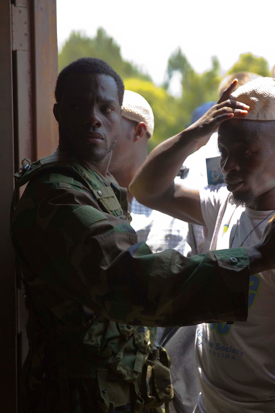 A role player portraying a security guard holds back a crowd at a simulated customs office during a mission rehearsal exercise for the next rotation of Special Purpose Marine Air Ground Task Force Africa aboard Marine Corps Auxiliary Landing Field Bogue, N.C., June 10, 2014. African natives who moved to the United States played a number of roles to give Marines with Combat Logistics Battalion 2 realistic training environment to prepare for an upcoming deployment.