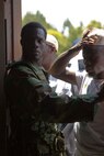 A role player portraying a security guard holds back a crowd at a simulated customs office during a mission rehearsal exercise for the next rotation of Special Purpose Marine Air Ground Task Force Africa aboard Marine Corps Auxiliary Landing Field Bogue, N.C., June 10, 2014. African natives who moved to the United States played a number of roles to give Marines with Combat Logistics Battalion 2 realistic training environment to prepare for an upcoming deployment.