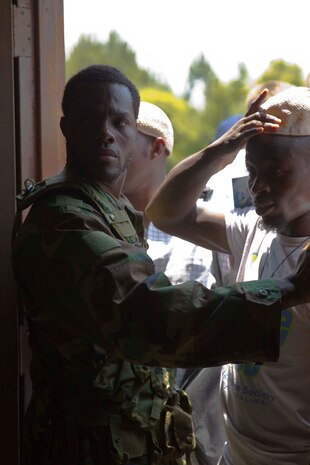 A role player portraying a security guard holds back a crowd at a simulated customs office during a mission rehearsal exercise for the next rotation of Special Purpose Marine Air Ground Task Force Africa aboard Marine Corps Auxiliary Landing Field Bogue, N.C., June 10, 2014. African natives who moved to the United States played a number of roles to give Marines with Combat Logistics Battalion 2 realistic training environment to prepare for an upcoming deployment.