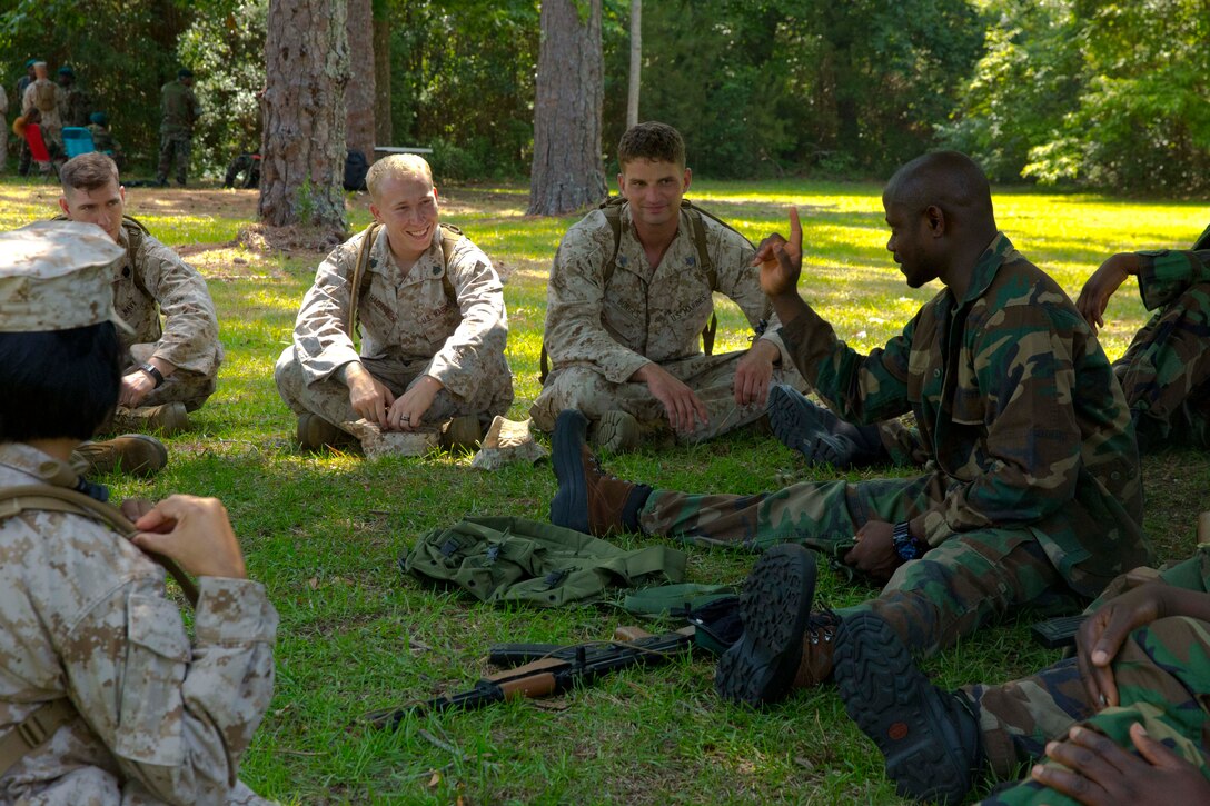 A theater security cooperation team with Combat Logistics Battalion 2 and role players share stories to build camaraderie during a mission rehearsal exercise aboard Marine Corps Auxiliary Landing Field Bogue, N.C., June 10, 2014. While deployed, theater security cooperation teams will train and work with partner African militaries to build enduring partnerships and bolster military capacity.