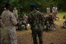 A hospital corpsman with Combat Logistics Battalion 2, 2nd Marine Logistics Group utilizes an interpreter to teach a combat lifesaver class to role players during a mission rehearsal exercise aboard Marine Corps Auxiliary Landing Field Bogue, N.C., June 10, 2014. The cultural differences between the role players and Marines, gave the Marines a unique perspective to how they should teach the classes and overall interact with their African counter parts.