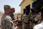 Army Staff Sgt. Jeff Schmidt (left) and Staff Sgt. Vern Baker, Task Force Raptor, U.S. Army 3rd Squadron, 124th Cavalry Regiment, Texas Army National Guard, discuss best practices with Djiboutian army soldiers at a border operations seminar at the Demining Djiboutian Army base here, March 14, 2012. Task Force Raptor Soldiers participated in various engagements with African militaries in support of Combined Joint Task Force - Horn of Africa.