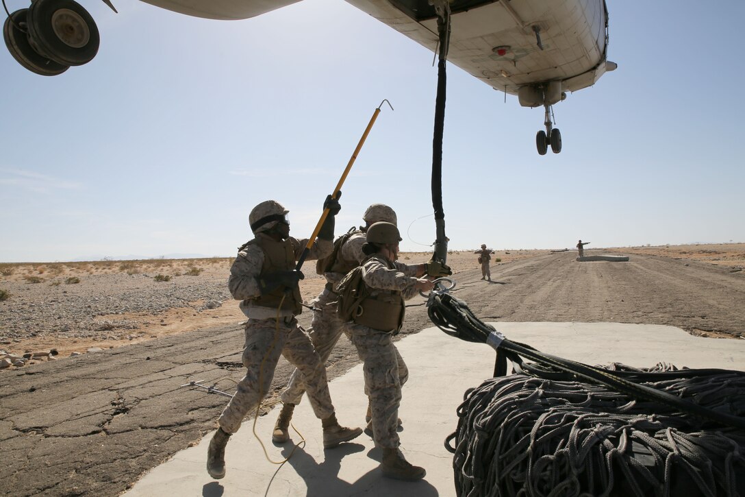 Marines from Combat Logistics Battalion 451, Combat Logistics Regiment 45, 4th Marine Logistics Group, train during an exercise that simulates a supply drop off/pick up during Integrated Training Exercise 4-14 aboard Marine Air Ground Combat Center Twentynine Palms, California, June 14, 2014. The purpose of the exercise is familiarizing the Marines with supply drops and pick-ups in areas where it might be too dangerous or the terrain is not suited for the helicopter to land. ITX 4-14 is the largest annual U.S. Marine Corps Reserve training exercise, which helps refine skills necessary to seamlessly integrate with active duty counterparts as well as operate as a complete Marine Air-Ground Task Force. (U.S. Marine photo by Sgt. Adwin Esters/Released)