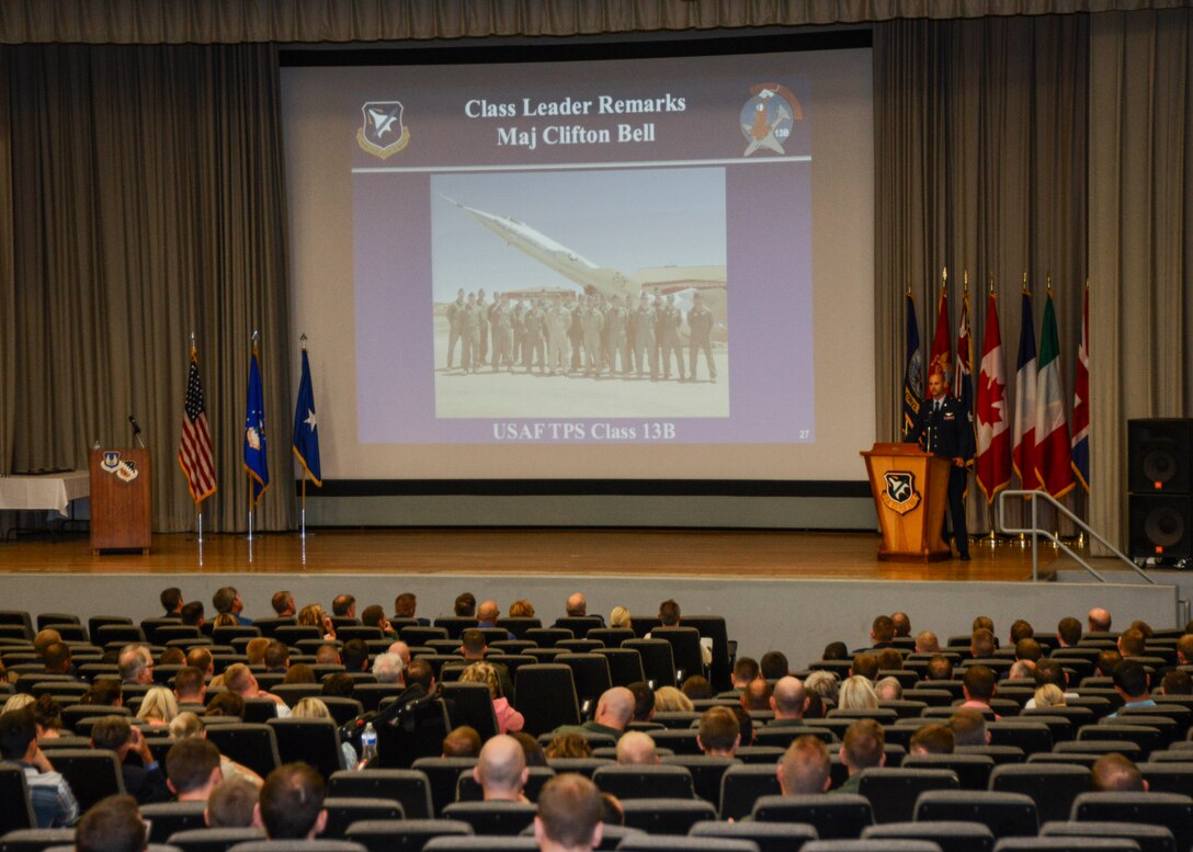 U.S. Air Force Test Pilot School Class 13B leader, Maj. Clifton Bell, addresses his fellow graduates, encouraging them to remember that the weapons systems they test today will be the same weapons systems their children take to war tomorrow. The class graduated June 13 with a ceremony at the base theater along with tours and presentations to commemorate the class and the 70th Anniversary of the creation of the test pilot school. (U.S. Air Force photo by Rebecca Amber) 