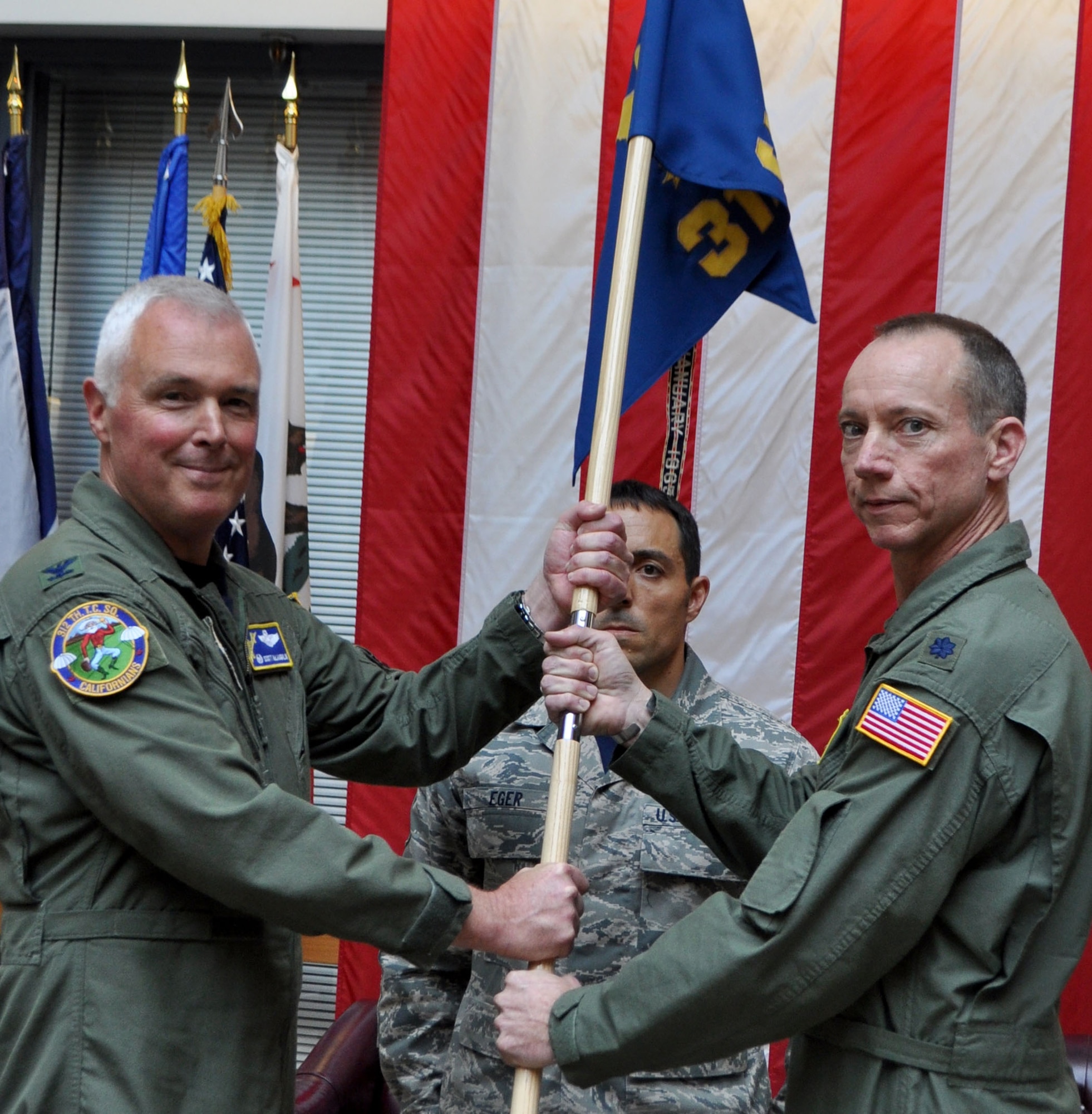 TRAVIS AIR FORCE BASE, Calif. -- In a time-honored tradition, the passing of a squadron flag signifies a change of command. Here, Lt. Col. Kevin Lane, 312th Airlift Squadron, passes the flag to 349th Operations Group Commander, Col. Scott McLaughlin, thus relinquishing command. (U.S. Air Force photo/Ellen Hatfield)