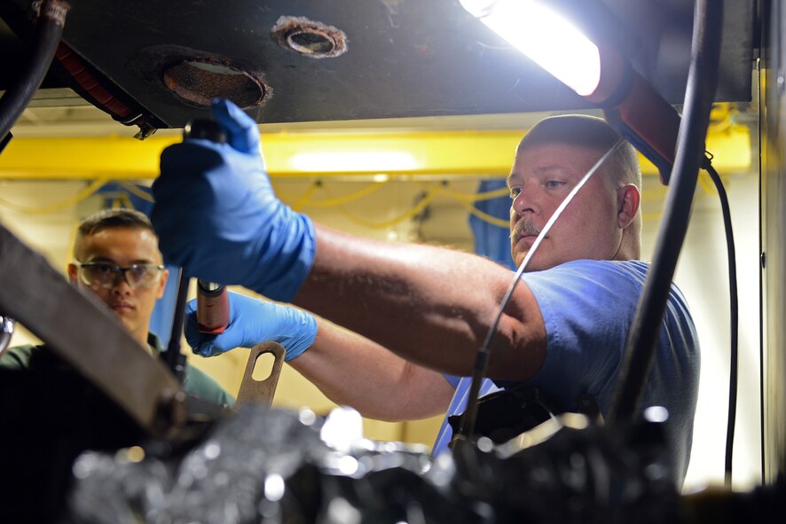 Dallas Nickerson (right), 62nd Maintenance Squadron aerospace ground equipment technician, demonstrates torqueing the engine head bolts on a MA-3D air conditioning unit to Airman 1st Class Jewell Ramos, 62nd MXS AGE technician, June 12, 2014, at Joint Base Lewis-McChord, Wash. Part of Nickerson’s responsibilities as an AGE mechanic is to train and mentor the shop’s new Airmen. (U.S. Air Force photo/Senior Airman Rebecca Blossom) 