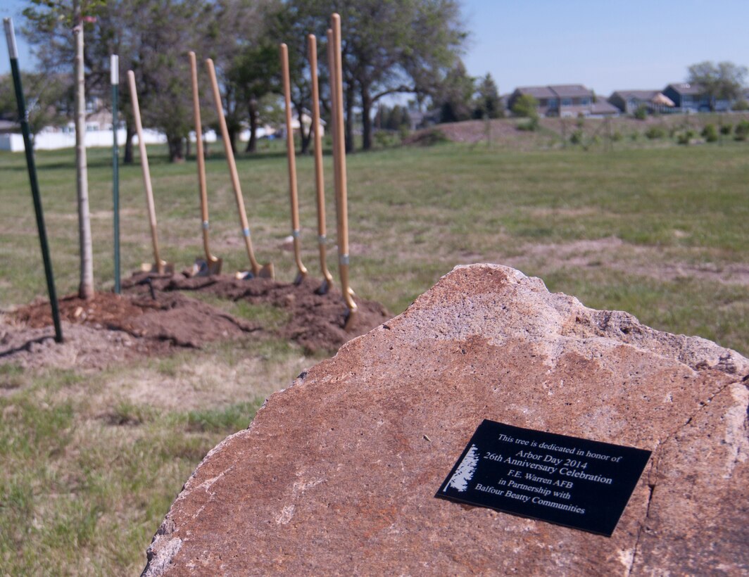 A plaque afixed to a rock near Randall Avenue and Atlas West housing on F.E. Warren Air Force Base, Wyo., reads: "This tree is dedicated in honor of Arbor Day 2014 26th Anniversary Celebration F.E. Warren AFB in Partnership with Balfour Beatty Communities." Ceremonial golden shovels await use to commemorate Arbor Day by breaking the ground where the tree is planted June 13, 2014. (U.S. Air Force photo by Airman 1st Class Jason Wiese)