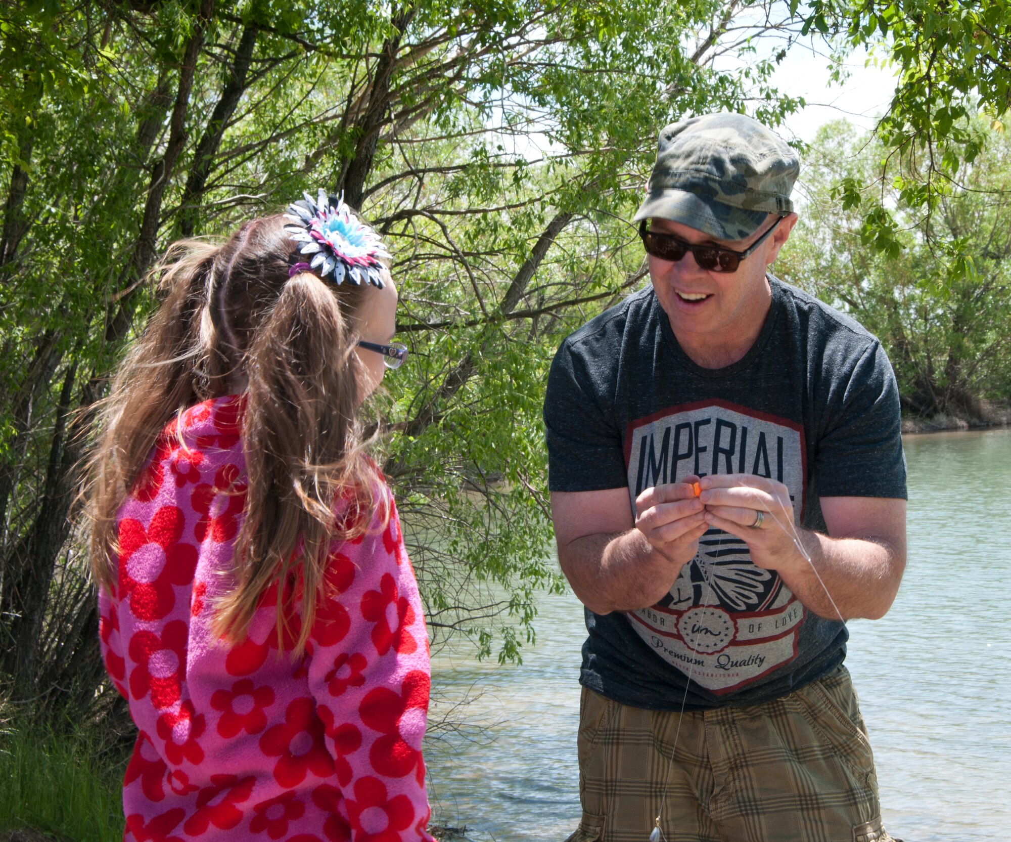 Scott, son of Retired Lt. Col. Jim McHugh, shows his daughter, Frida, how to attach a bobber to a fishing line during the Father's Day Fishing Derby June 15, 2014, at the F.E. Warren Base Lake. (U.S. Air Force photo by Airman 1st Class Jason Wiese)