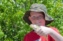 Wyatt, son of Tech. Sgt. Kevin Adams, 90th Missile Security Forces Squadron, holds up a perch he caught at the F.E. Warren Basle Lake during the Father's Day Fishing Derby June 15, 2014. (U.S. Air Force photo by Airman 1st Class Jason Wiese)