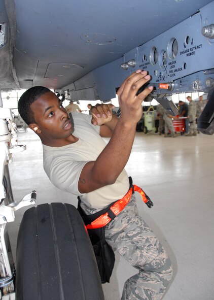 Senior Airman Luis Cleveland, of the 96th Aircraft Maintenance Squadron Red, verifies that a fuel tank station is properly secure before loading a CATM-120 missile and a preloaded BRU-61 bomb rack unit onto an F-15 Strike Eagle, during the 96th Maintenance Group’s quarterly weapons load crew competition June 13 at Eglin Air Force Base, Fla. Cleveland, Staff Sgt. Adrian Pamintuan and Airman 1st Class Luke Odom, defeated the Blue AMU F-16 team in the competition.  (U.S. Air Force photo/Kevin Gaddie)